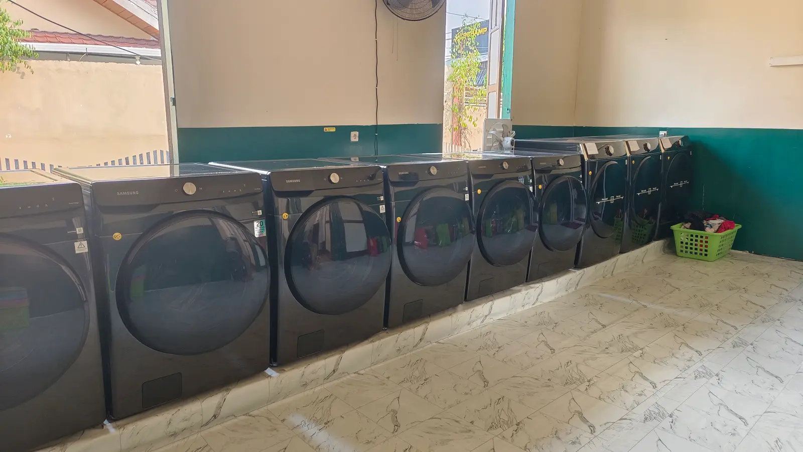 Barisan mesin cuci dan pengering di area self-service