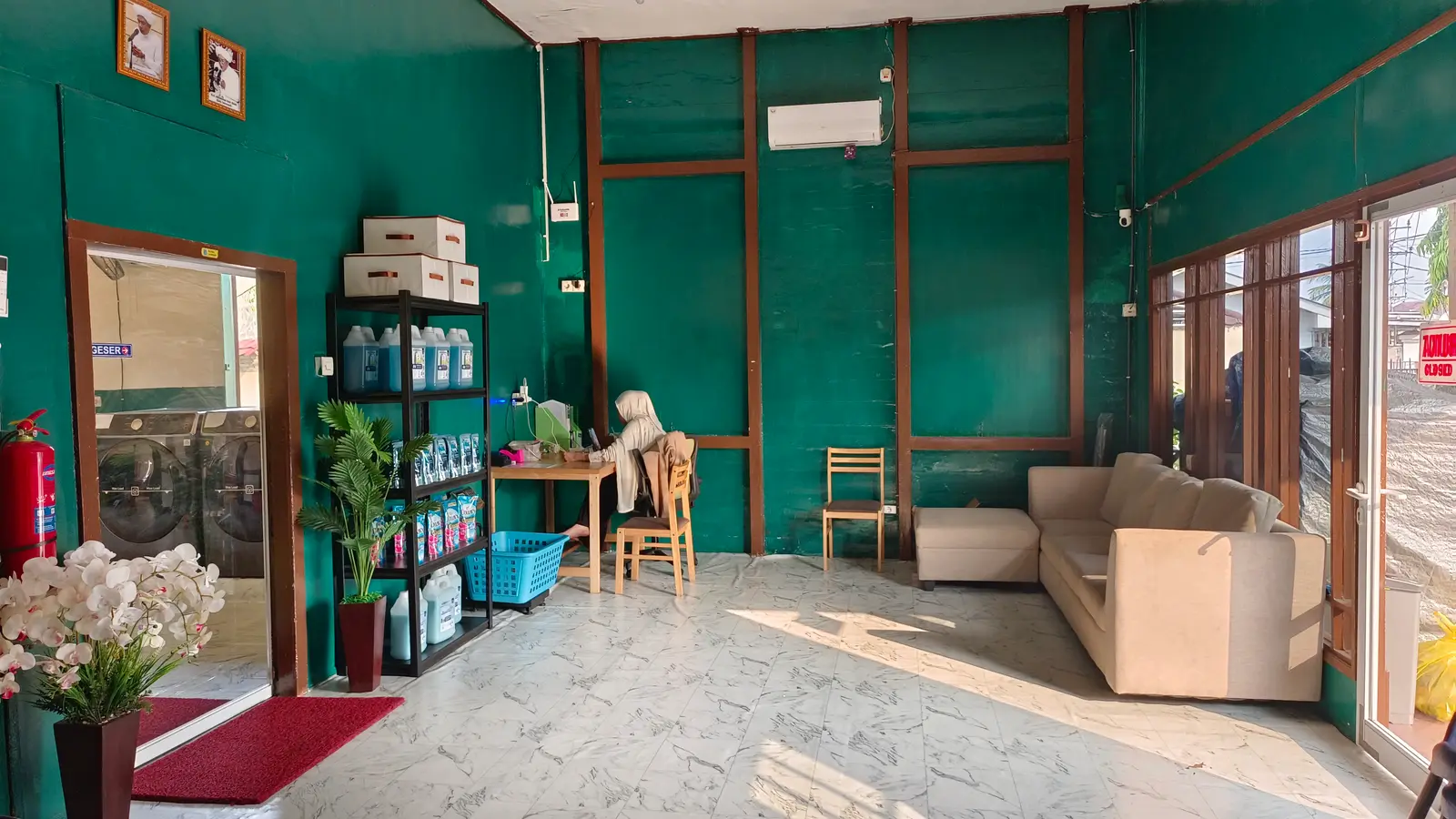 Ruang tunggu luas dengan sofa, meja, dan AC